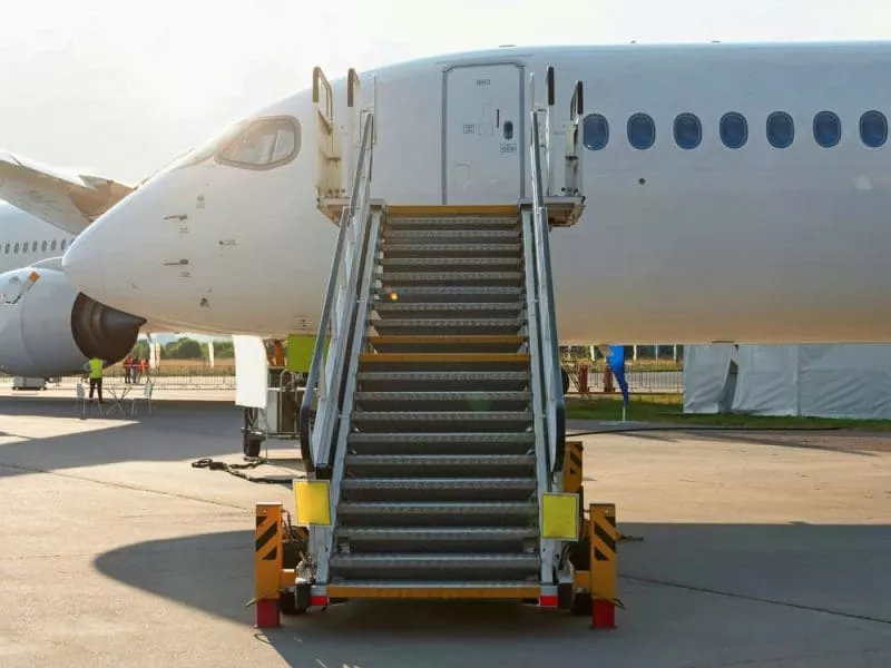 Aircraft maintenance steps with a mobile staircase positioned under an airplane