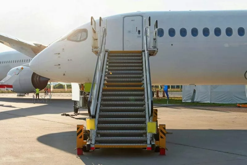 Aircraft maintenance steps with a mobile staircase positioned under an airplane