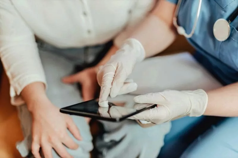 HCP showing tablet to patient