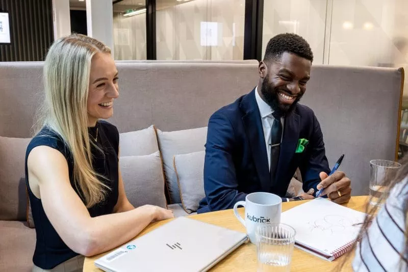 Man and woman smiling in kitchen during brainstorm